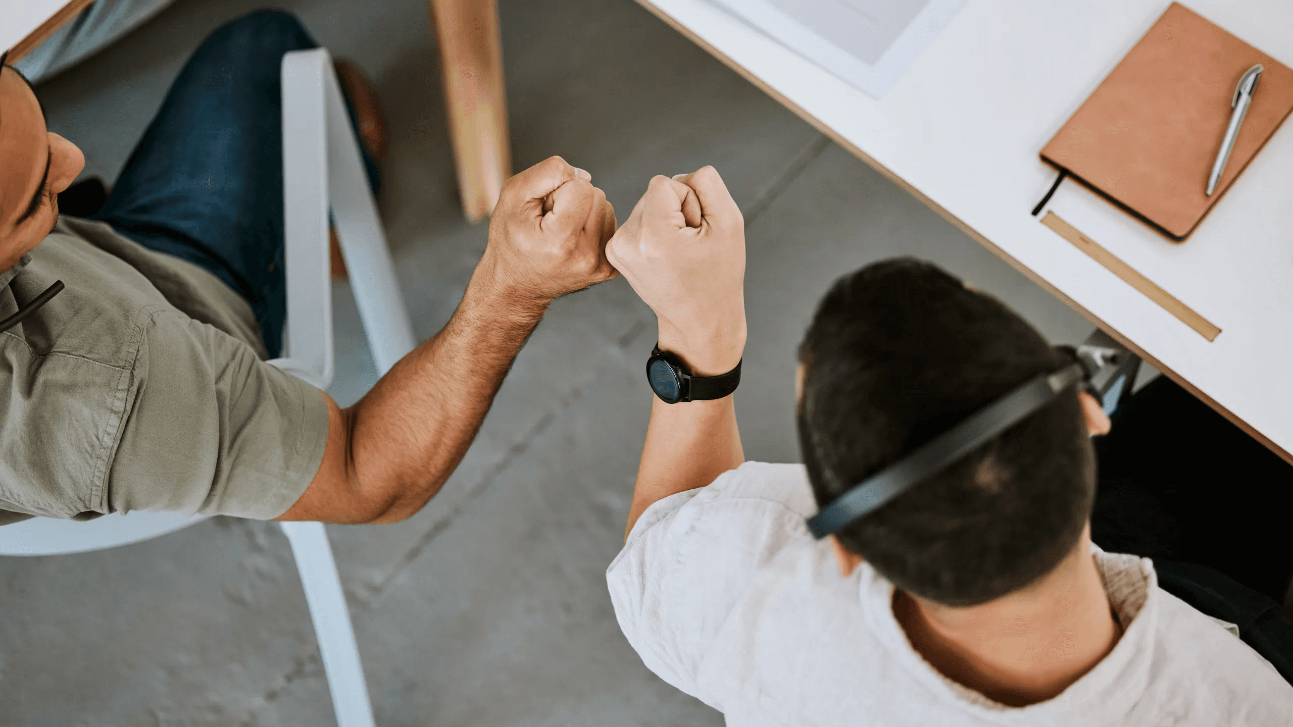 People fist-bumping at a desk